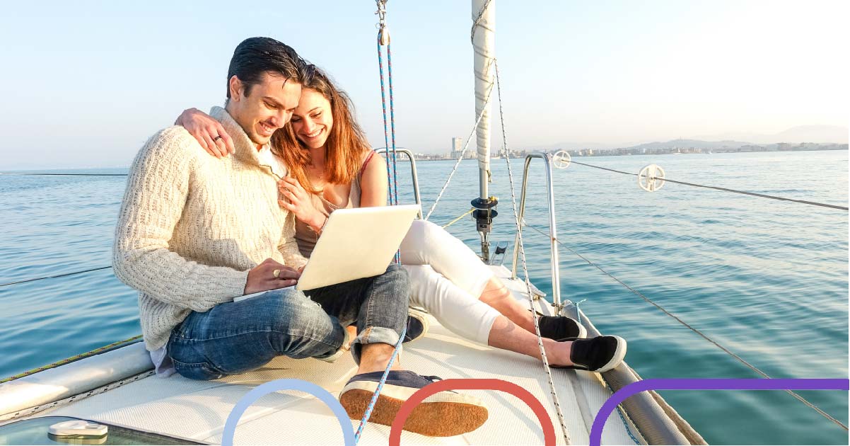 Two people sit on their laptop on a yacht